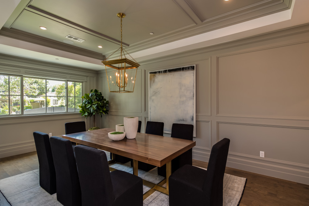 Design ideas for a large transitional dining room in Los Angeles with grey walls, medium hardwood floors, no fireplace, brown floor, coffered and panelled walls.