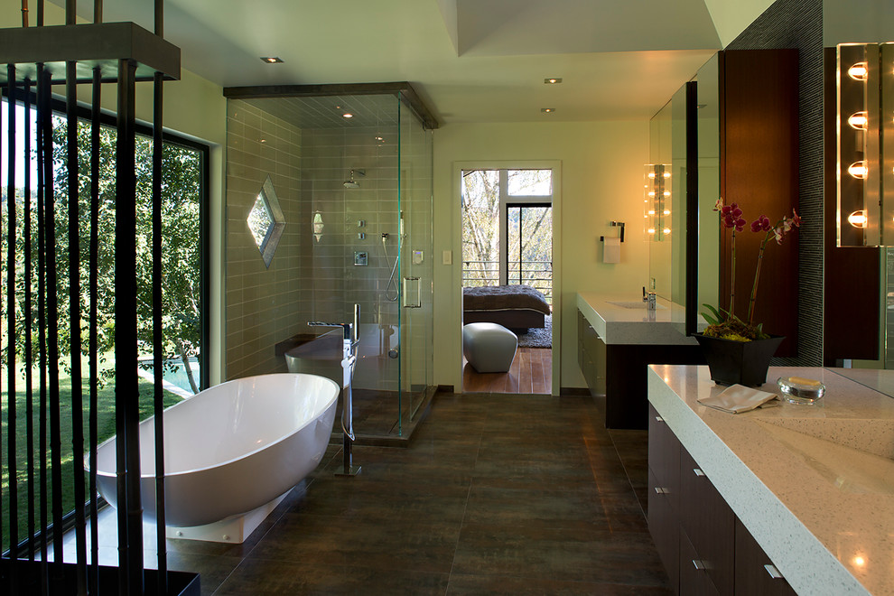 Photo of an asian master bathroom in San Francisco with flat-panel cabinets, dark wood cabinets, a freestanding tub, an alcove shower, porcelain floors, an integrated sink, quartzite benchtops and a hinged shower door.