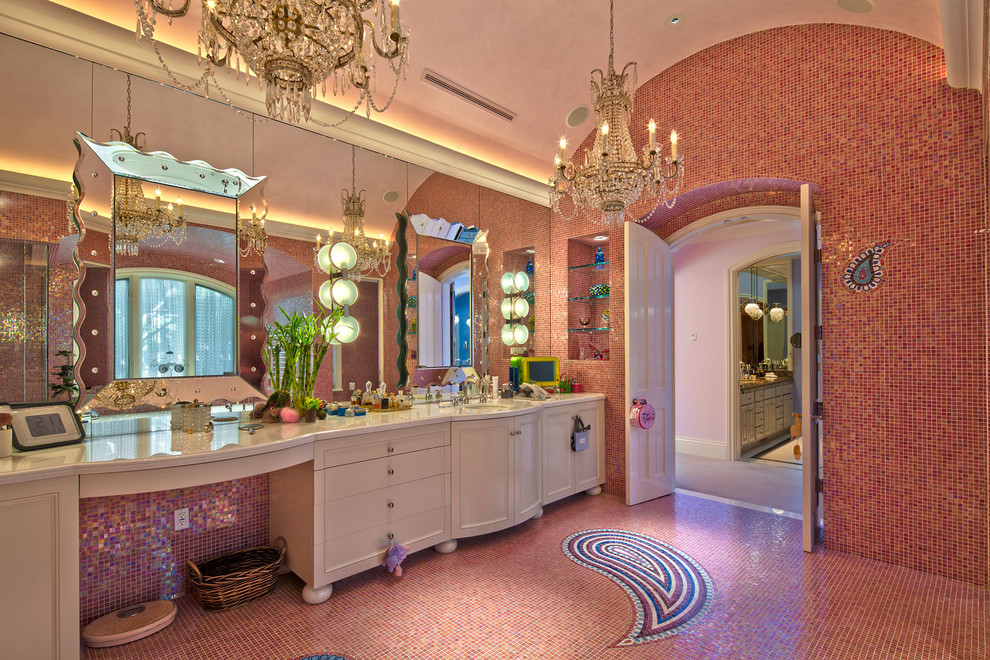 This is an example of a large eclectic master bathroom in Los Angeles with white cabinets, an alcove tub, a corner shower, pink tile, mosaic tile, pink walls, mosaic tile floors, an undermount sink, solid surface benchtops, pink floor, a hinged shower door and recessed-panel cabinets.