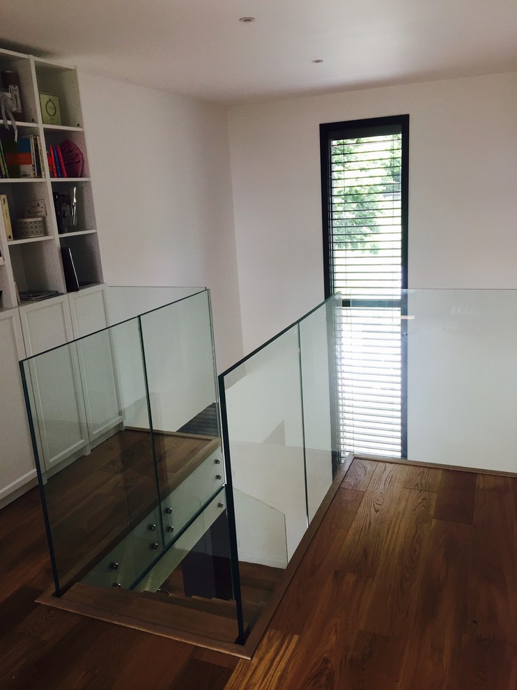 Photo of a contemporary wood straight staircase in Rennes with open risers and glass railing.