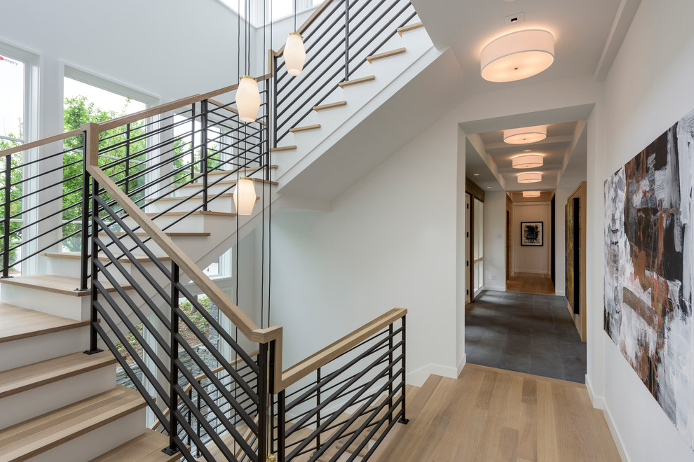 Large contemporary wood u-shaped staircase in Minneapolis with painted wood risers.