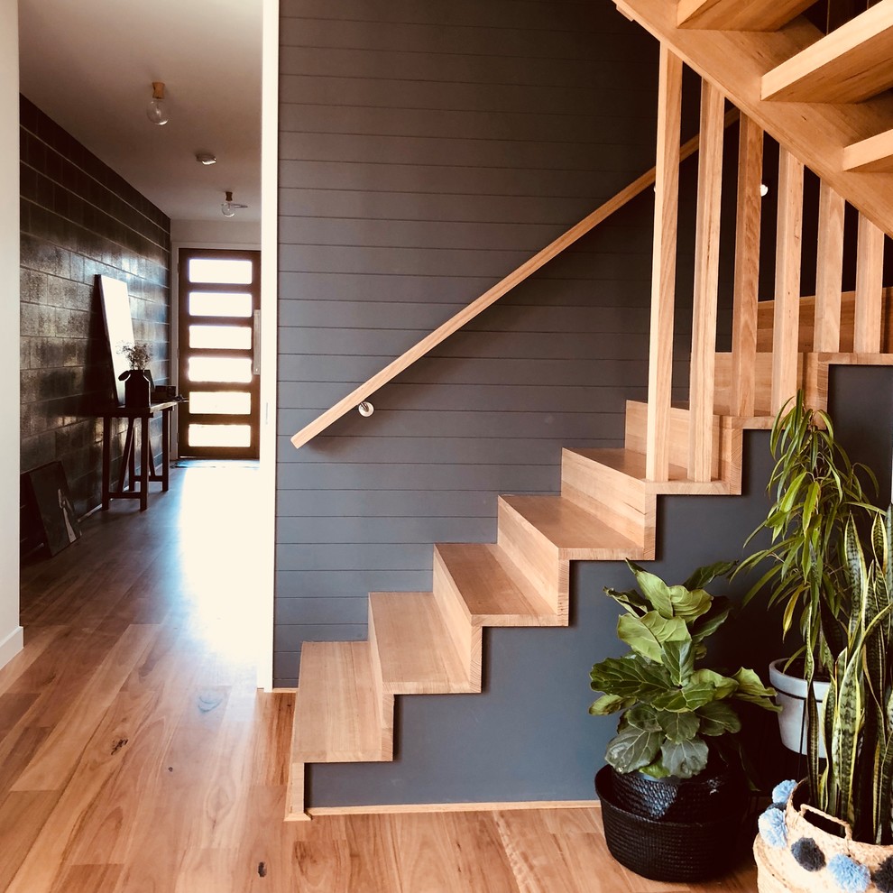 Inspiration for a mid-sized beach style wood u-shaped staircase in Other with wood risers and wood railing.