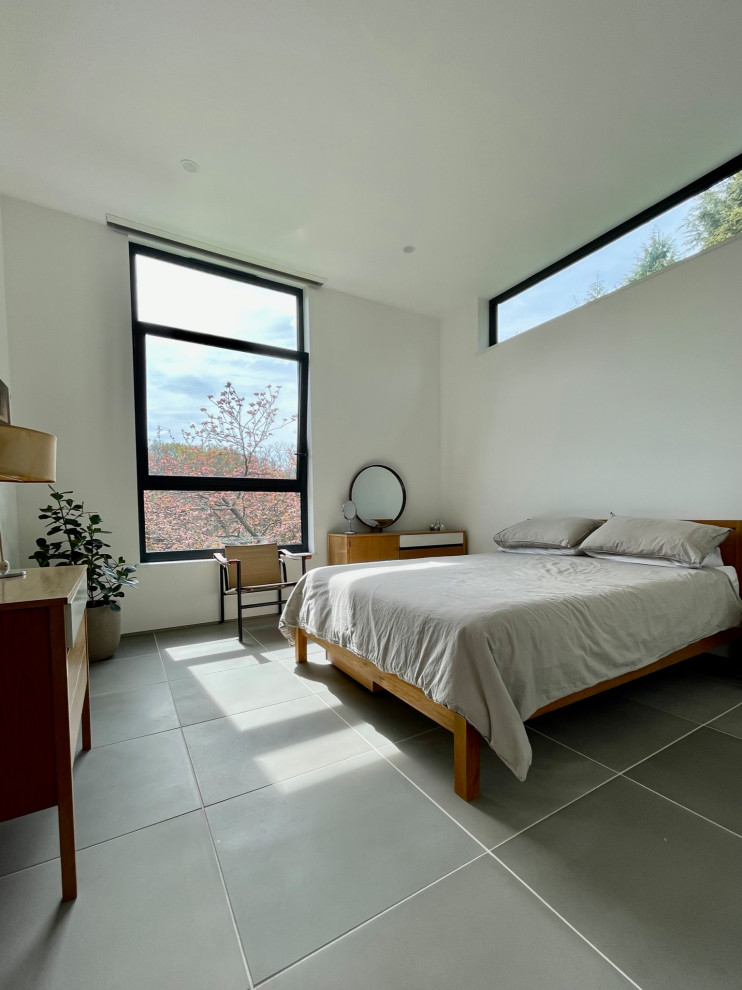 Aménagement d'une chambre d'amis contemporaine de taille moyenne avec un mur blanc, un sol en carrelage de céramique et un sol gris.