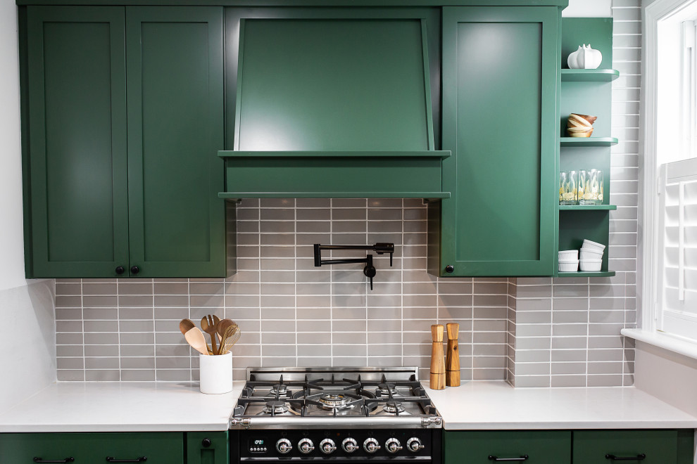 Photo of a mid-sized transitional l-shaped eat-in kitchen in Philadelphia with an undermount sink, shaker cabinets, green cabinets, quartz benchtops, brown splashback, porcelain splashback, black appliances, porcelain floors, a peninsula, multi-coloured floor and white benchtop.