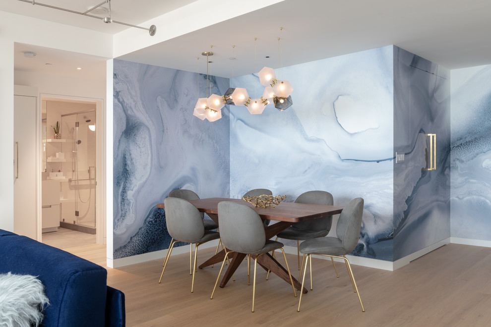 This is an example of a contemporary open plan dining in San Francisco with beige floor, blue walls and light hardwood floors.