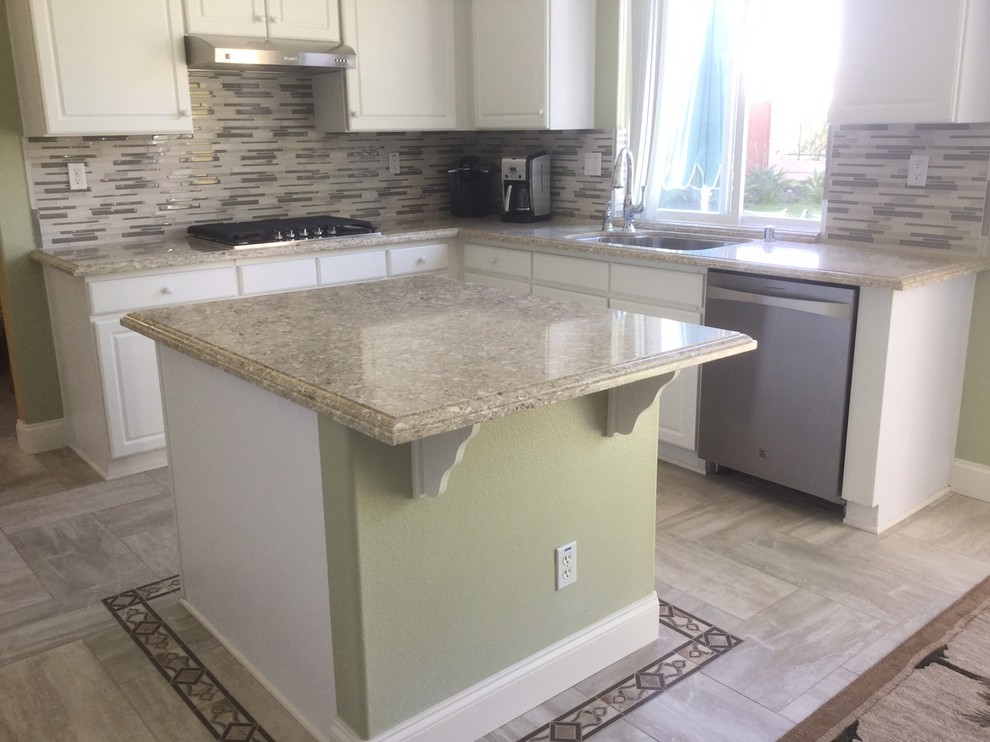 Design ideas for a mid-sized traditional l-shaped eat-in kitchen in San Diego with an undermount sink, raised-panel cabinets, white cabinets, granite benchtops, grey splashback, mosaic tile splashback, stainless steel appliances, porcelain floors and with island.