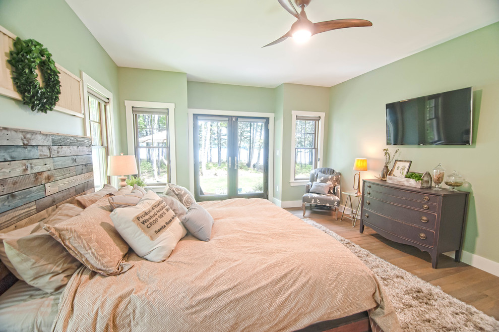 Design ideas for a large arts and crafts master bedroom in Portland Maine with green walls, medium hardwood floors and brown floor.