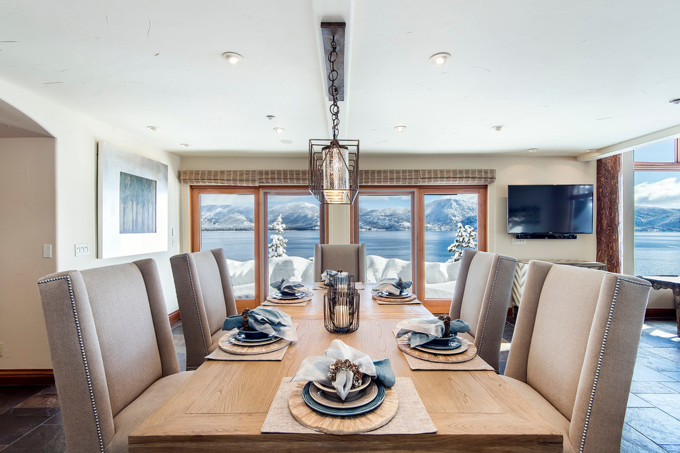 Example of a mid-sized transitional slate floor great room design with beige walls, a wood stove and a stone fireplace