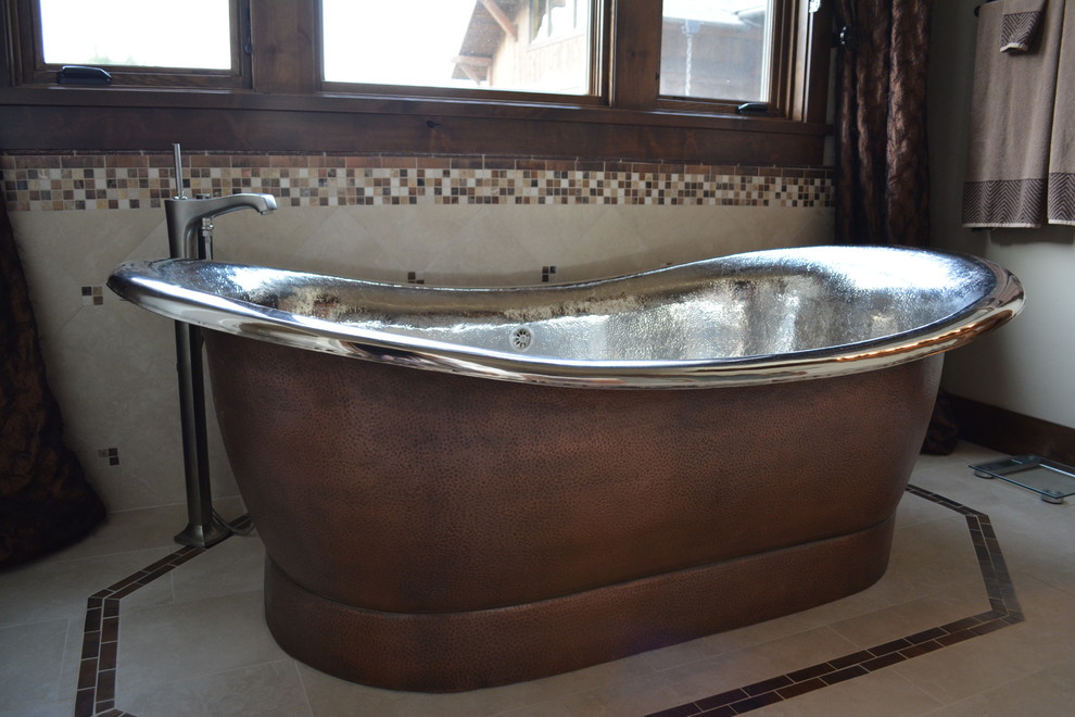 Freestanding bathtub - mid-sized rustic master beige tile, black and white tile, brown tile, gray tile and porcelain tile porcelain tile freestanding bathtub idea with raised-panel cabinets, medium tone wood cabinets, white walls, a drop-in sink and solid surface countertops