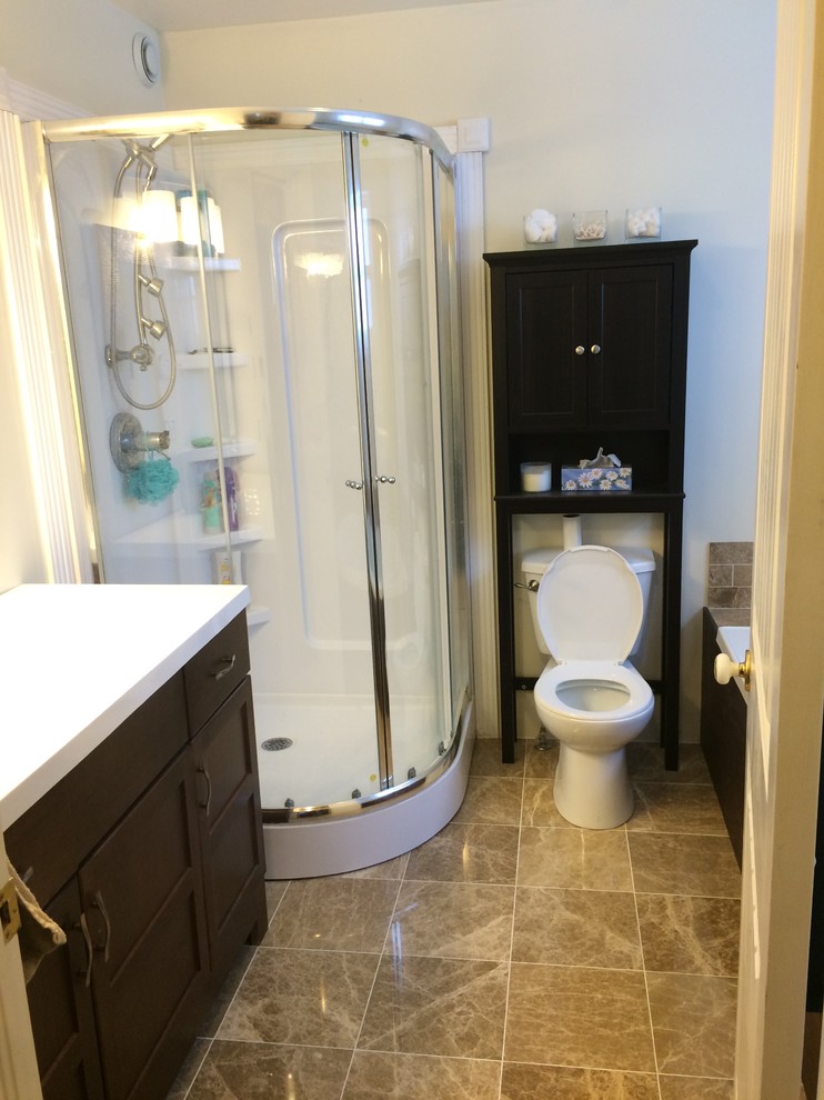 Example of a mid-sized transitional master beige tile and porcelain tile porcelain tile corner shower design with shaker cabinets, dark wood cabinets, gray walls and solid surface countertops
