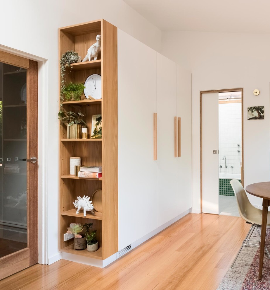 Inspiration for a small scandinavian kitchen/dining combo in Melbourne with white walls, light hardwood floors and brown floor.