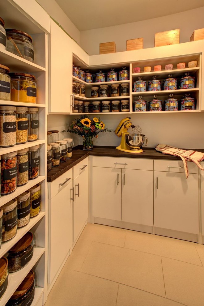 Inspiration for a large contemporary porcelain tile kitchen pantry remodel in New York with flat-panel cabinets, white cabinets and wood countertops