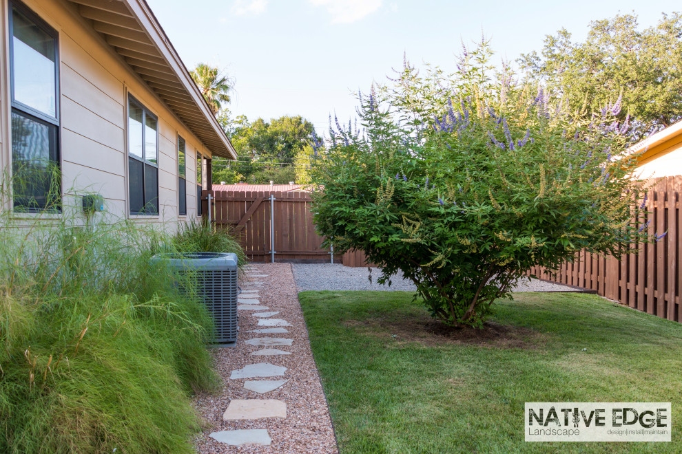 Photo of a mid-sized modern side yard partial sun xeriscape for summer in Austin with with raised garden bed, natural stone pavers and a wood fence.