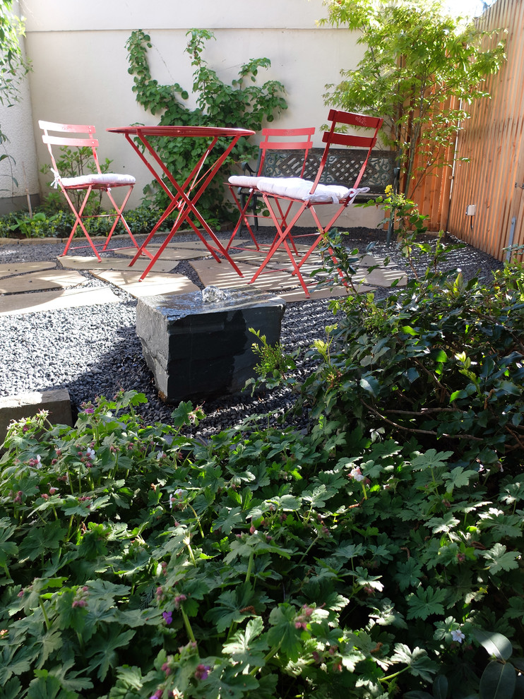 Inspiration for a small midcentury backyard patio in Cologne with gravel.