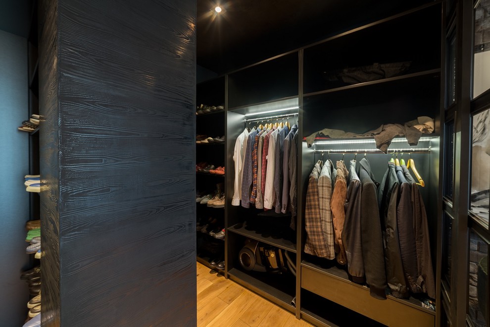This is an example of a mid-sized country men's storage and wardrobe in Other with light hardwood floors.