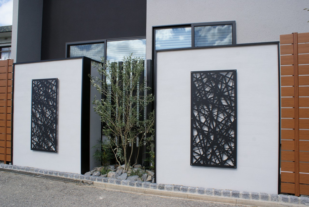 Foto di un giardino minimalista esposto a mezz'ombra di medie dimensioni e davanti casa in autunno con pavimentazioni in pietra naturale e recinzione in PVC