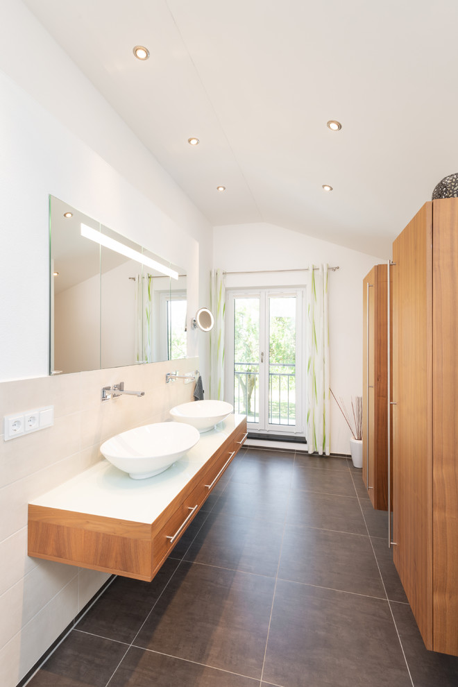 Inspiration for a small contemporary master bathroom in Nuremberg with flat-panel cabinets, medium wood cabinets, beige tile, ceramic tile, white walls, porcelain floors, a vessel sink, wood benchtops, grey floor and white benchtops.