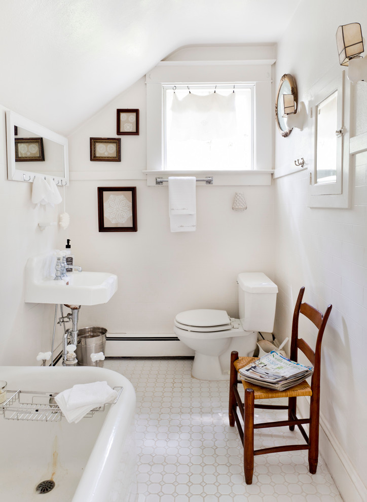 Photo of a traditional bathroom in New York with a wall-mount sink, a freestanding tub and white walls.