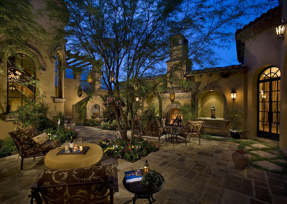 Inspiration for a mediterranean courtyard patio in Phoenix with a fire feature.