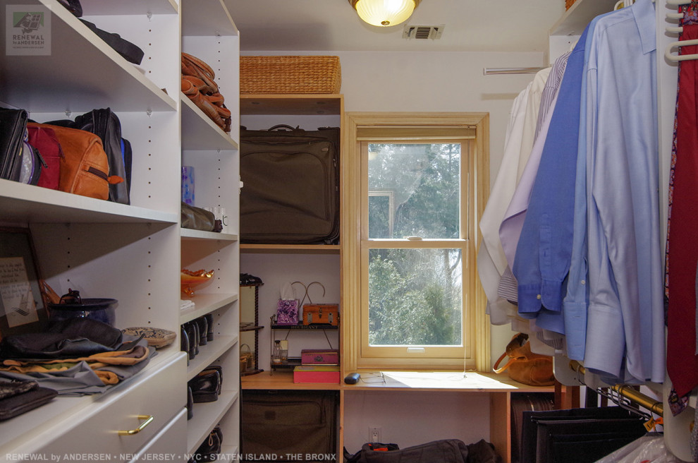 Imagen de armario vestidor de hombre grande con armarios abiertos, puertas de armario de madera clara, moqueta y suelo beige
