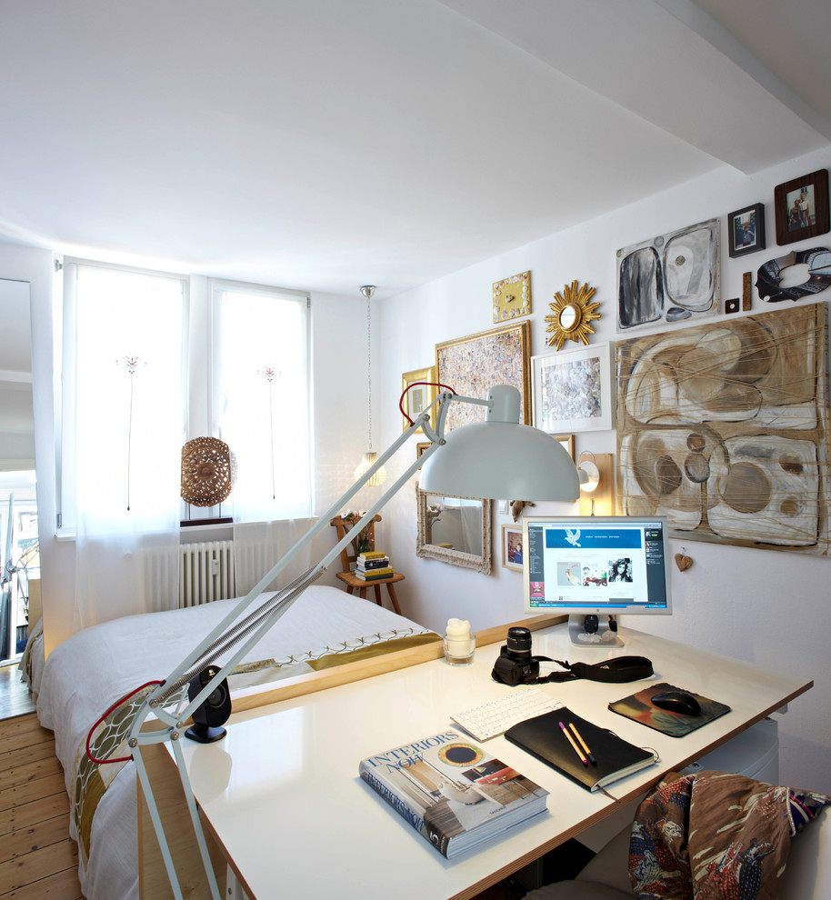 This is an example of a small contemporary study room in Munich with white walls, light hardwood floors, a freestanding desk and beige floor.