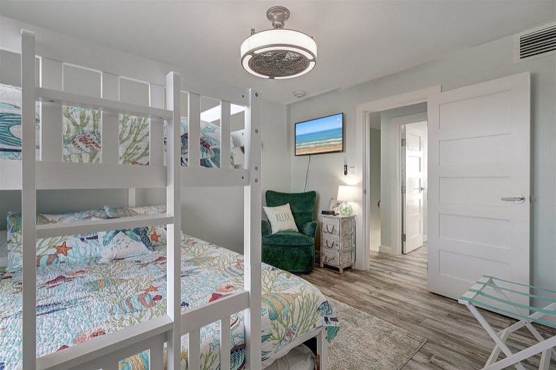 Design ideas for a mid-sized beach style guest bedroom in Austin with blue walls, porcelain floors, no fireplace and grey floor.