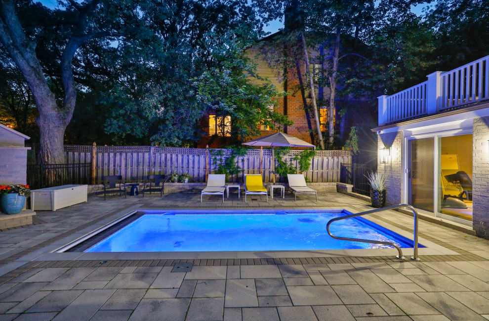 Imagen de casa de la piscina y piscina alargada clásica pequeña rectangular en patio trasero con adoquines de hormigón
