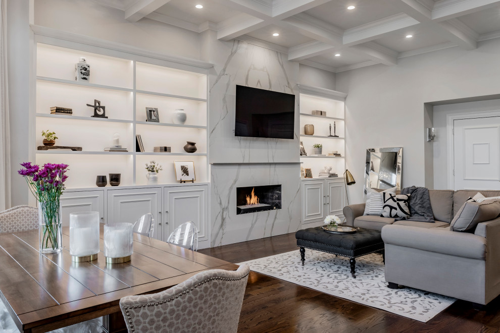 Photo of a large transitional open concept living room in Boston with grey walls, medium hardwood floors, a standard fireplace, a tile fireplace surround, a wall-mounted tv, brown floor and coffered.