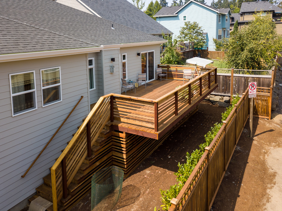 Example of a large transitional backyard deck design with no cover