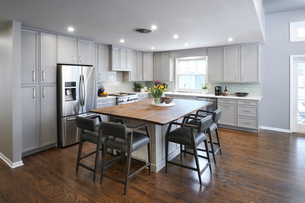 Example of a l-shaped eat-in kitchen design with flat-panel cabinets, gray cabinets and an island