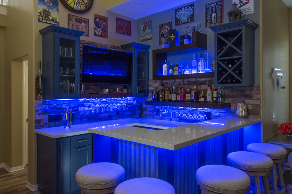 Inspiration for a large country u-shaped seated home bar in Los Angeles with no sink, open cabinets, blue cabinets, quartzite benchtops, red splashback, brick splashback, medium hardwood floors and brown floor.