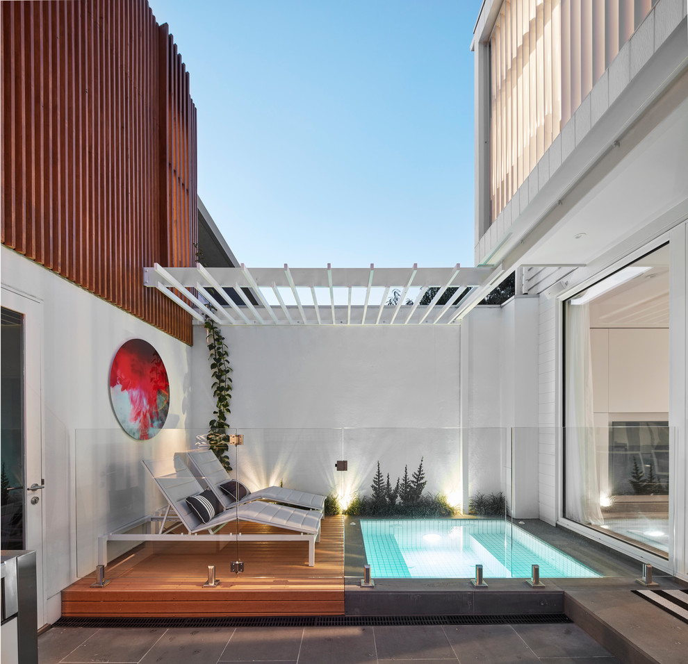 This is an example of a small contemporary backyard pool in Melbourne with a hot tub and decking.