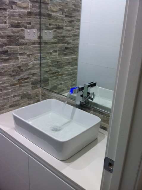 Photo of a small contemporary master bathroom in Sydney with a vessel sink, flat-panel cabinets, white cabinets and multi-coloured tile.