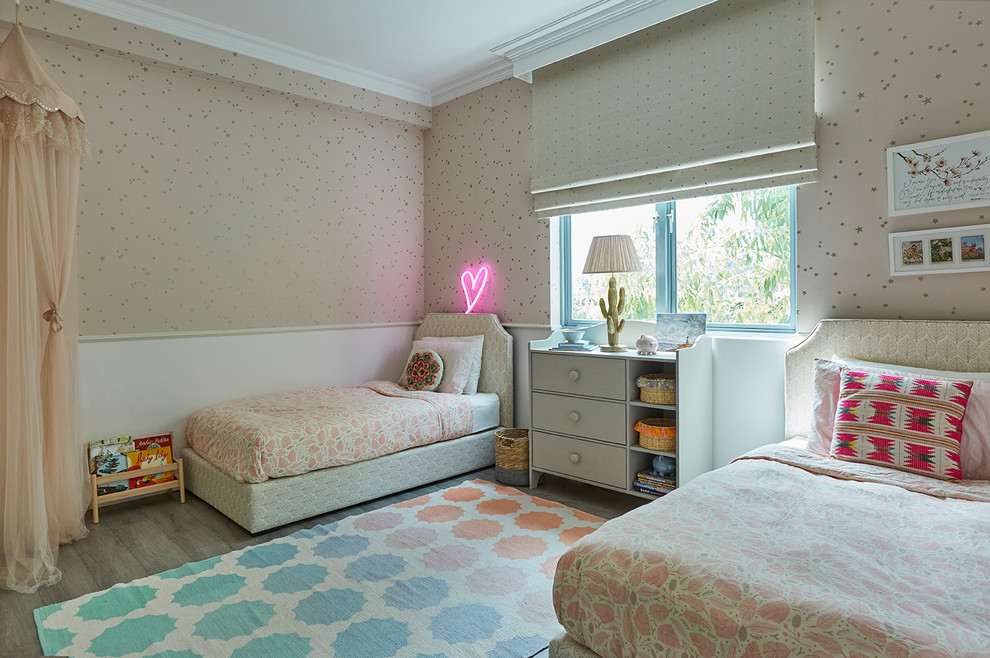This is an example of a transitional kids' bedroom for girls in Singapore with beige walls, light hardwood floors and grey floor.