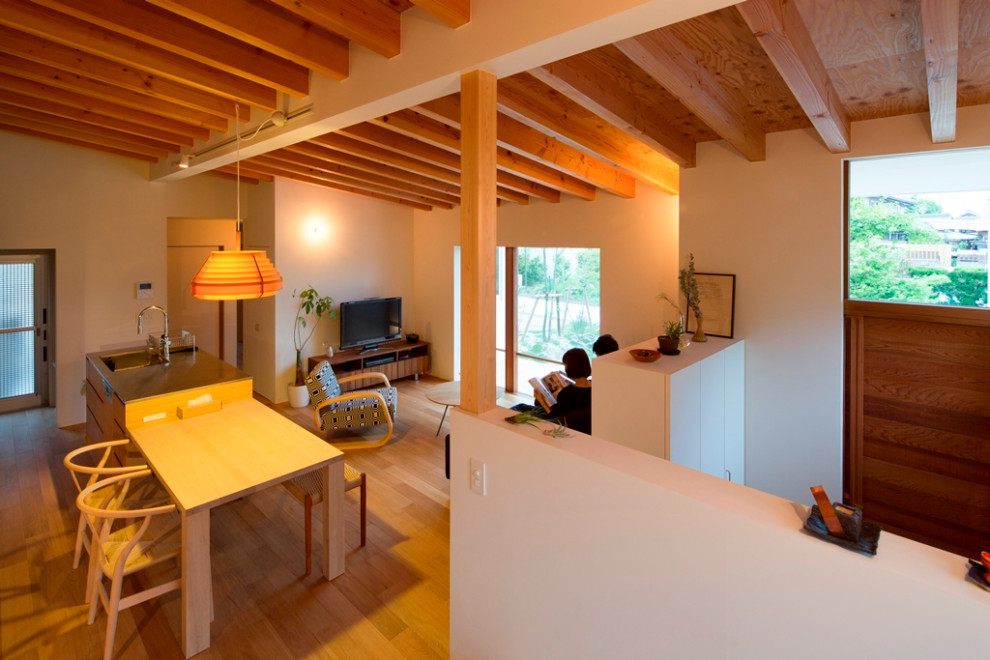 This is an example of a small scandinavian galley open plan kitchen in Nagoya with an integrated sink, flat-panel cabinets, medium wood cabinets, stainless steel benchtops, stainless steel appliances, medium hardwood floors, with island, beige floor, beige benchtop and exposed beam.