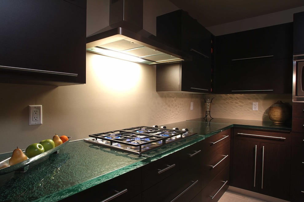 Photo of a contemporary u-shaped eat-in kitchen in New York with an undermount sink and glass benchtops.