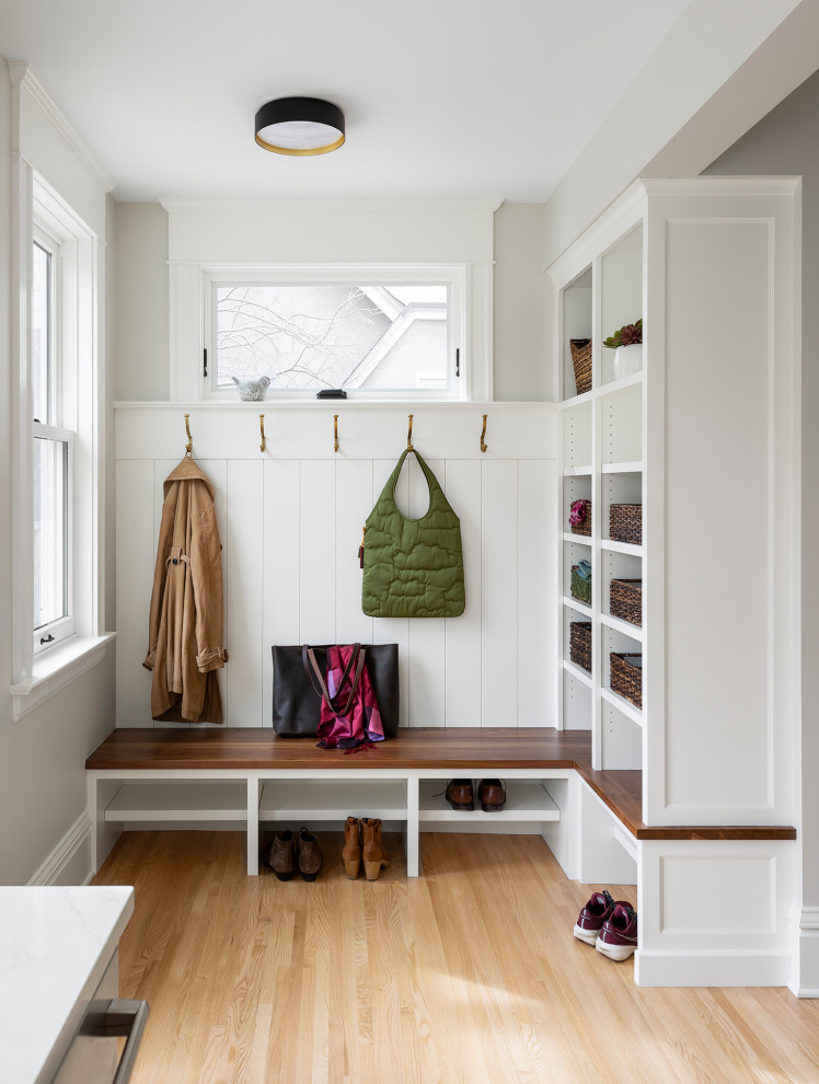 Large transitional u-shaped light wood floor and beige floor entryway photo in Minneapolis with a farmhouse sink, recessed-panel cabinets, blue cabinets, quartz countertops, multicolored backsplash, ceramic backsplash, stainless steel appliances, an island and white countertops