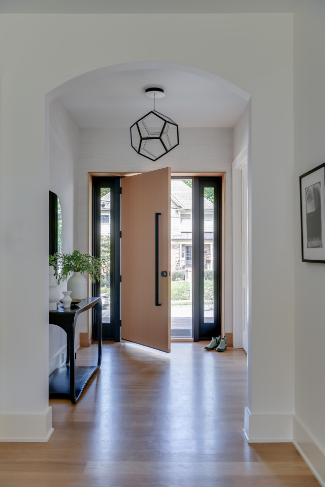 На фото: фойе среднего размера в современном стиле с коричневыми стенами, светлым паркетным полом, одностворчатой входной дверью, входной дверью из светлого дерева, коричневым полом и обоями на стенах