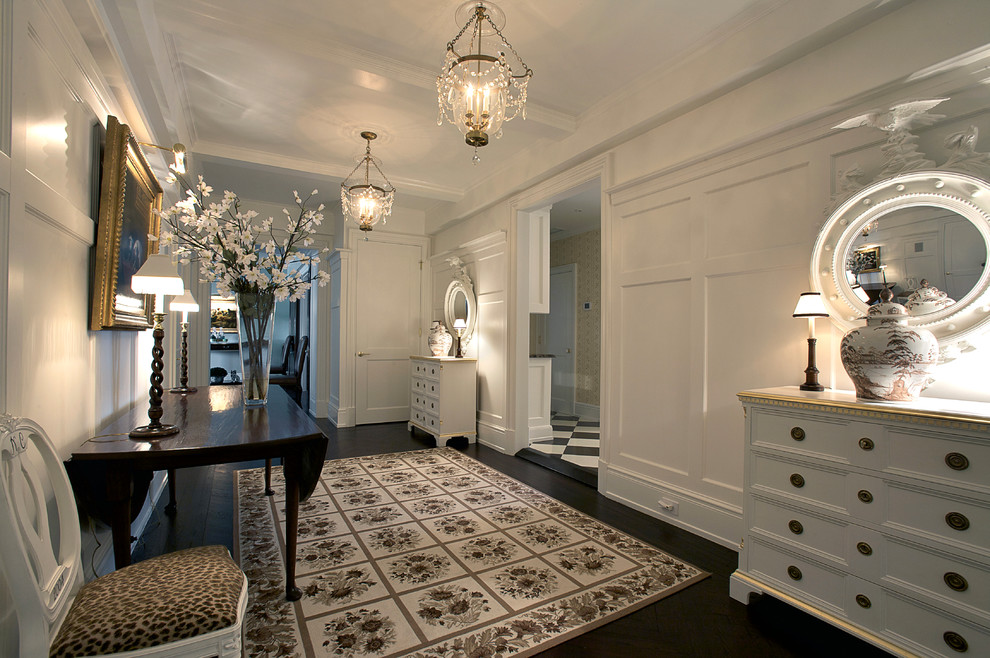 Photo of a large traditional foyer in New York with white walls and dark hardwood floors.