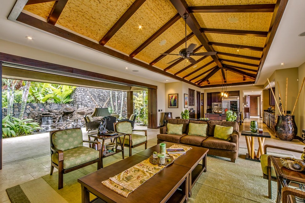 Expansive tropical formal open concept living room in Hawaii with beige walls, travertine floors and no fireplace.