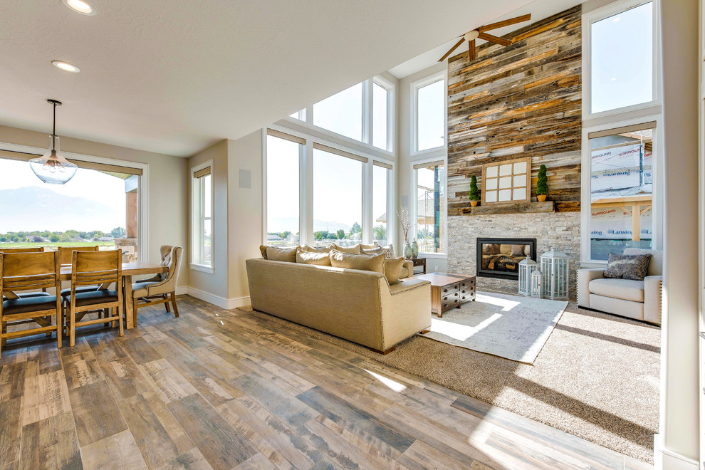 Large contemporary open concept family room in Salt Lake City with multi-coloured walls, a standard fireplace, a brick fireplace surround, no tv, brown floor and carpet.