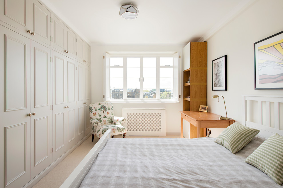 Mid-sized traditional bedroom in London with beige walls, carpet and beige floor.