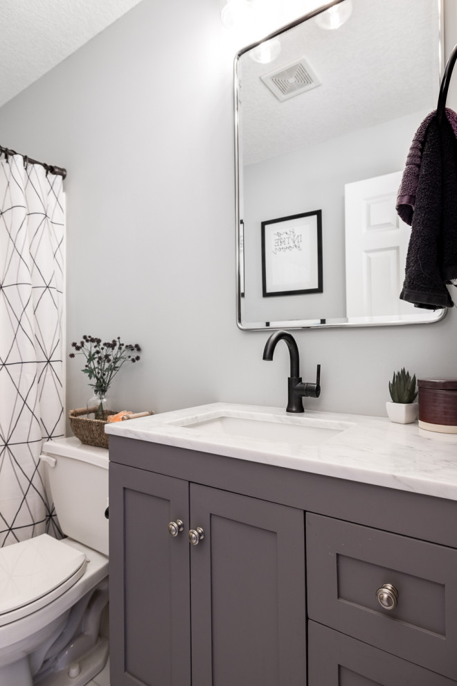 Inredning av ett litet vit vitt badrum med dusch, med skåp i shakerstil, grå skåp, ett badkar i en alkov, en dusch/badkar-kombination, en toalettstol med separat cisternkåpa, grå väggar, vinylgolv, ett undermonterad handfat, bänkskiva i kvarts, vitt golv och dusch med duschdraperi