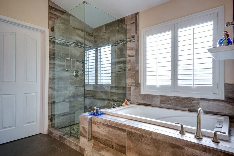 Contemporary master bathroom in Las Vegas with a drop-in tub, a shower/bathtub combo, brown tile, ceramic tile, blue walls, pebble tile floors and tile benchtops.
