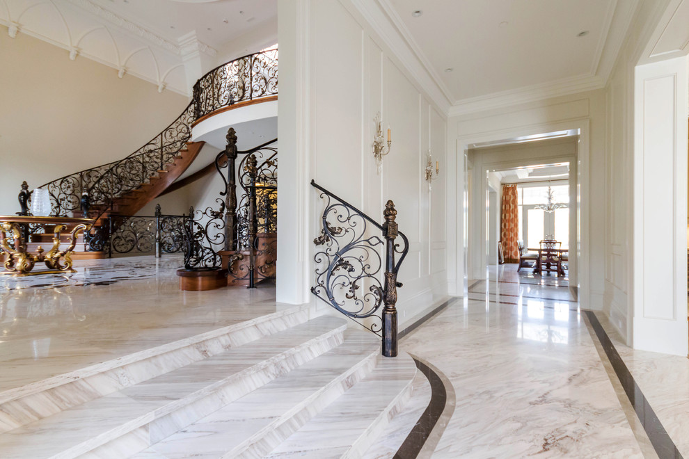 This is an example of a large traditional hallway in Toronto with white walls, marble floors and grey floor.