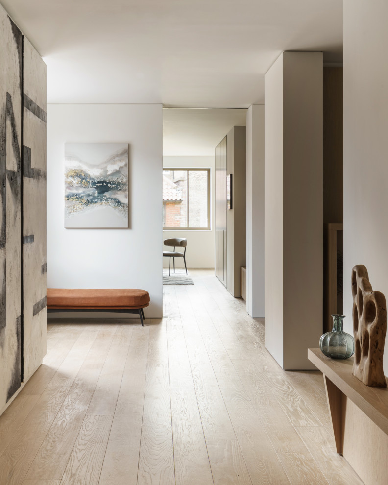 Photo of a large contemporary hallway in London with beige walls, light hardwood floors and beige floor.