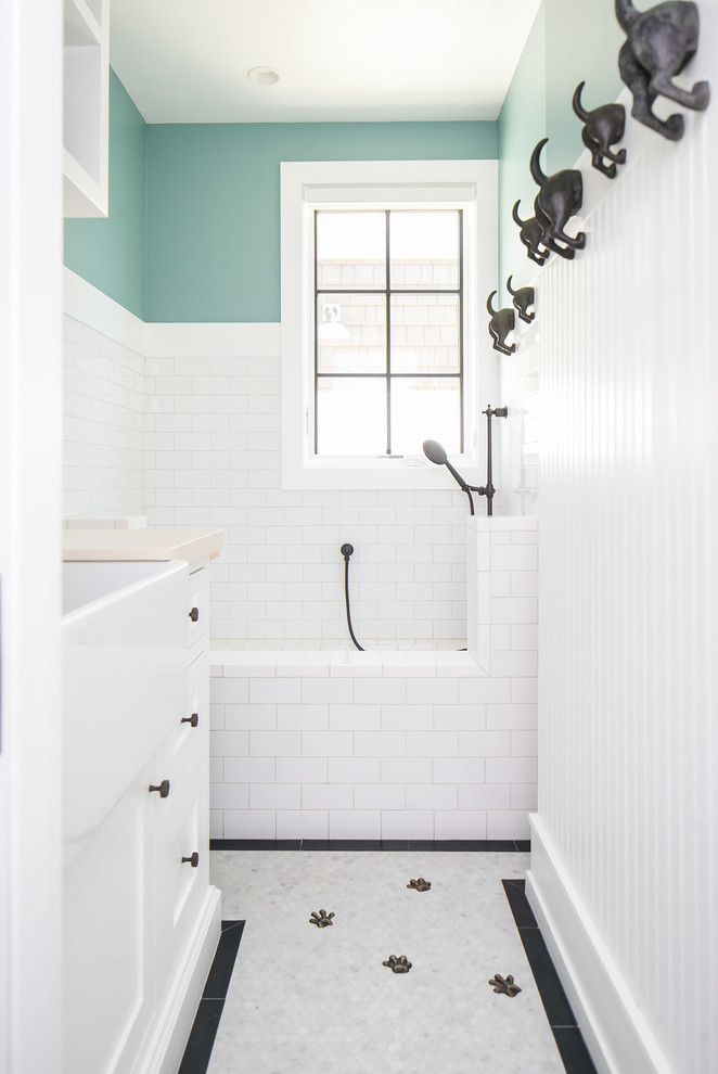 This is an example of a mid-sized tropical kids bathroom in Orange County with shaker cabinets, white cabinets, an open shower, white tile, subway tile, green walls, grey floor and an open shower.
