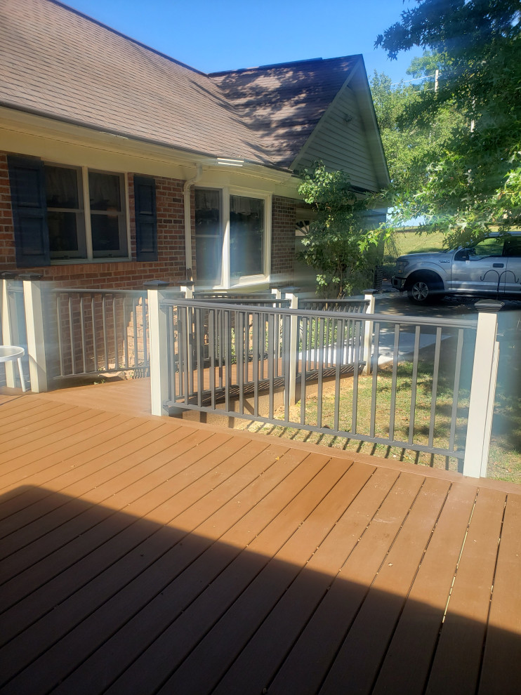 Trendy ground level metal railing deck photo with a roof extension