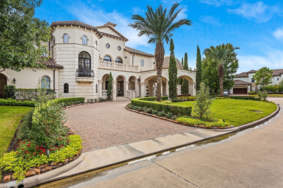 Mediterranean two-storey beige house exterior in Houston with a tile roof.