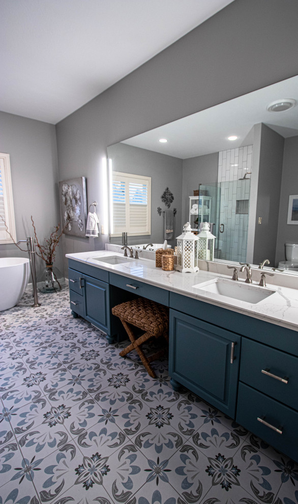 Design ideas for a medium sized coastal ensuite bathroom in Cleveland with raised-panel cabinets, a freestanding bath, an alcove shower, a two-piece toilet, white tiles, ceramic tiles, grey walls, ceramic flooring, a submerged sink, granite worktops, blue floors, a hinged door, white worktops, a wall niche, double sinks and a built in vanity unit.